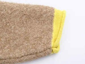 Macro shot of brown faux shearling knitwear with bright yellow ribbed cuffs detail