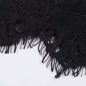 Detail of black lace fabric with delicate crochet patterns and eyelash trim edge