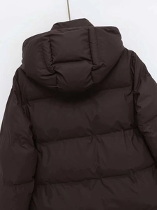 Detail of dark brown hooded puffer jacket featuring horizontal quilting and matte fabric