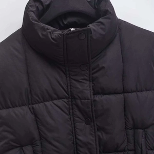 Women's black quilted puffer vest with high stand collar and metallic snap buttons