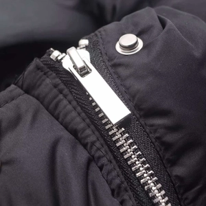 Women's black quilted vest featuring premium silver metal zipper and snap button details