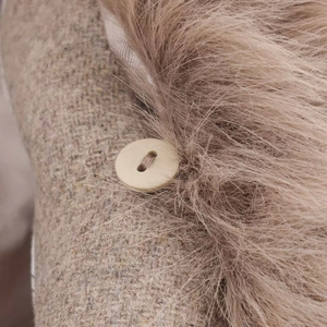 Detail of wool coat with faux fur collar and decorative beige round button