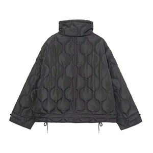 Détail d'une veste matelassée noire avec col montant et ourlet à cordon de serrage