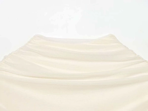 Detail of light beige mesh fabric with fine gathered ruched texture for summer dress