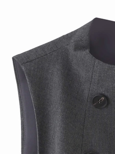 Dettaglio ravvicinato del gilet senza maniche grigio scuro con bottoni neri e trama fine