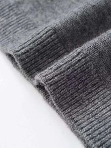 Close-up of fine grey knit texture and rib knit cuffs of a high neck short sleeve sweater