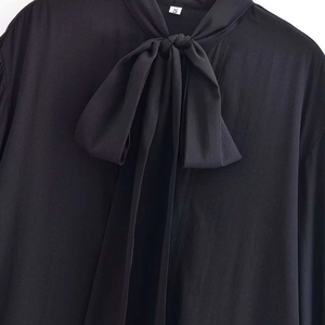 Elegant black long sleeve V-neck blouse with a large bow-tie collar and fluid drape