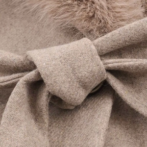 Detail of khaki wool coat featuring a plush faux fur collar and matching waist tie