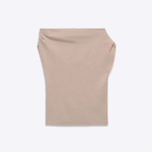 Close-up of the fine ribbed texture on a beige strapless knitted tube top for summer