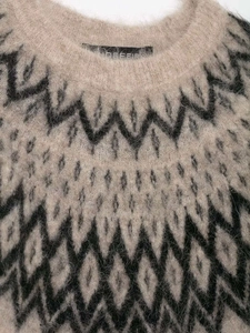 Detailaufnahme der weichen Alpakawolle und des geometrischen Fair-Isle-Strickmusters