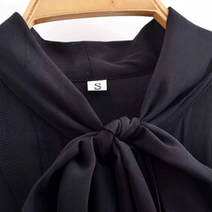 Elegant black V-neck shirt featuring a front bow tie design on a wooden hanger