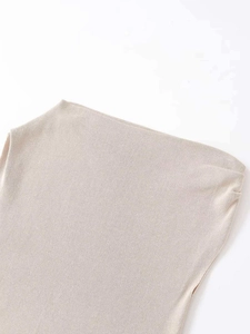 Detailed close-up of light beige ribbed knit fabric showing fine texture and clean hem