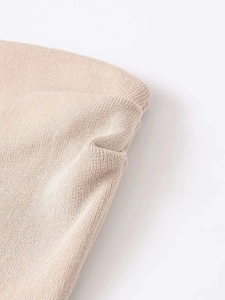 Macro detail of apricot knit fabric showing fine texture and quality stitching