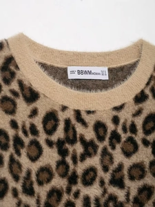Close-up of leopard jacquard knit sweater neck with ribbed trim and soft texture