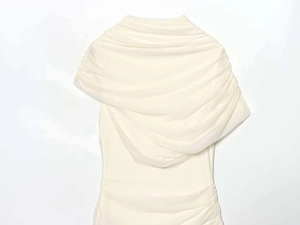 Detail of cream-white ruched dress featuring an elegant off-shoulder pleated neckline