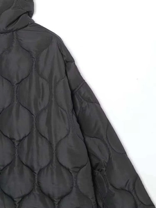Vue détaillée de la veste matelassée noire avec coutures en oignon en tissu de nylon