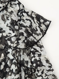 Detailed view of lightweight black and white ink print fabric with ruffle edges