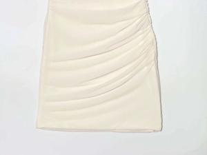 Detailed macro view showing the ruched design and texture of the beige bodycon dress