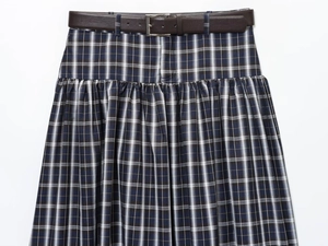 Close-up of navy plaid midi skirt with pleated texture and brown faux leather belt