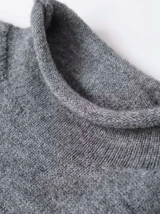 Macro shot of grey high-neck knit sweater collar showing fine texture and rolled edges