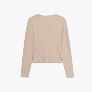 Detail view of the back of a beige ribbed knit top featuring delicate lace splicing texture