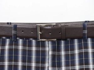 Detail of dark blue plaid pattern and textured brown belt with silver square buckle
