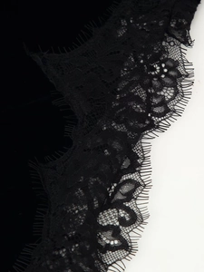 Gros plan sur la bordure en dentelle de cils noire et les motifs floraux de la robe