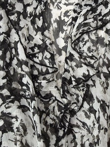 Detailed macro view of black and white abstract print fabric with layered ruffles design