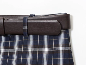 Detailed view of the dark blue plaid fabric and the brown leather belt on the waistline
