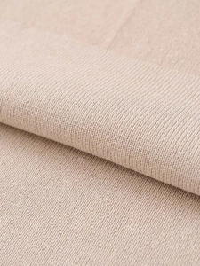 Close-up of the beige ribbed knit fabric showing detailed texture and fine weaving quality
