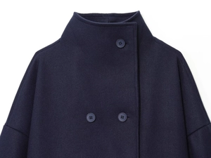 Close-up of the asymmetric stand collar and buttons on a dark wool coat