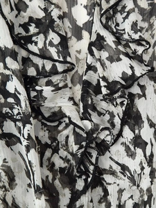 Detailed macro view of black and white abstract floral print chiffon with layered ruffles