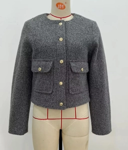 Détail de la veste courte en tweed gris foncé avec d'élégants boutons dorés en métal