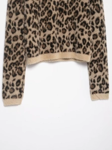 Detail of soft leopard print knit sweater featuring plush texture and ribbed cuffs