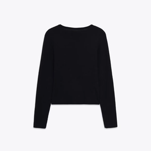 Close-up of black ribbed knit cardigan featuring lace patchwork and sleek round neck design