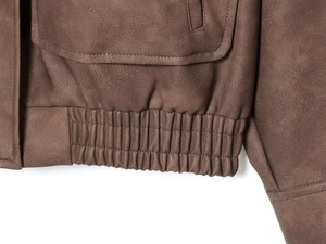 Detail der dunkelbraunen Wildlederjacke mit elastischem Saum und Pattentaschen
