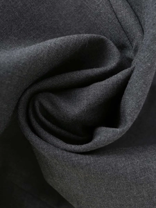 Dettaglio del tessuto grigio scuro che mostra il drappeggio liscio e la trama fine