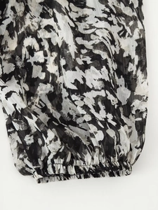 Detailed close-up of elastic ruffled cuffs on a black and white abstract print dress