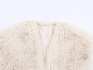 Detalle del chaleco de pelo sintético beige con forro suave y textura de cuello en V