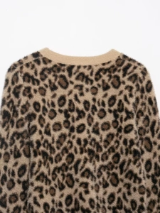 Detail of soft leopard print knit texture and ribbed crew neck collar on sweater