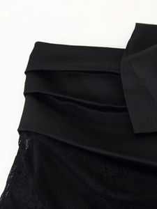 Detail showing the contrast between smooth black satin and delicate floral lace fabric