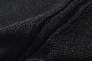 Gros plan sur la texture en maille noire avec des motifs côtelés épais et doux au toucher