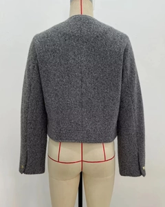 Détail du dos d'une veste courte grise avec boutons dorés et texture en tweed