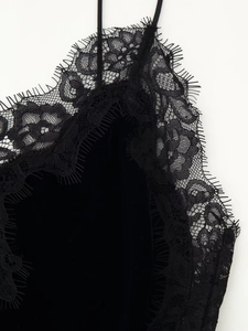 Gros plan d'une robe en velours noir avec bordure en dentelle cil et fines bretelles