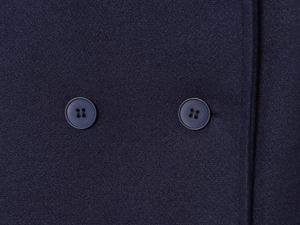 Detail of dark blue wool coat featuring matching double-breasted four-hole buttons