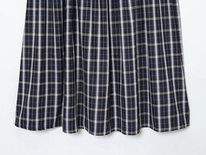 Detailed macro view of navy and yellow plaid pleated skirt fabric with fine weaving