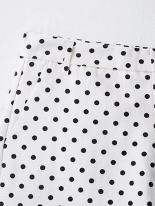 Detail view of white casual shorts featuring black polka dots and side pocket stitching