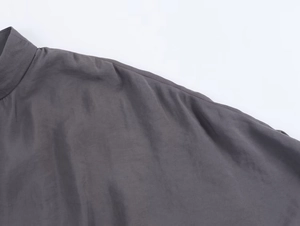 Detail of dark grey satin fabric featuring a small stand-up collar and smooth shoulder seams