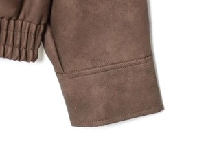 Detailaufnahme einer braunen Wildlederjacke mit Ärmelnaht und elastischer Taille