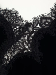 Gros plan sur la dentelle florale noire délicate et bordure de la robe velours